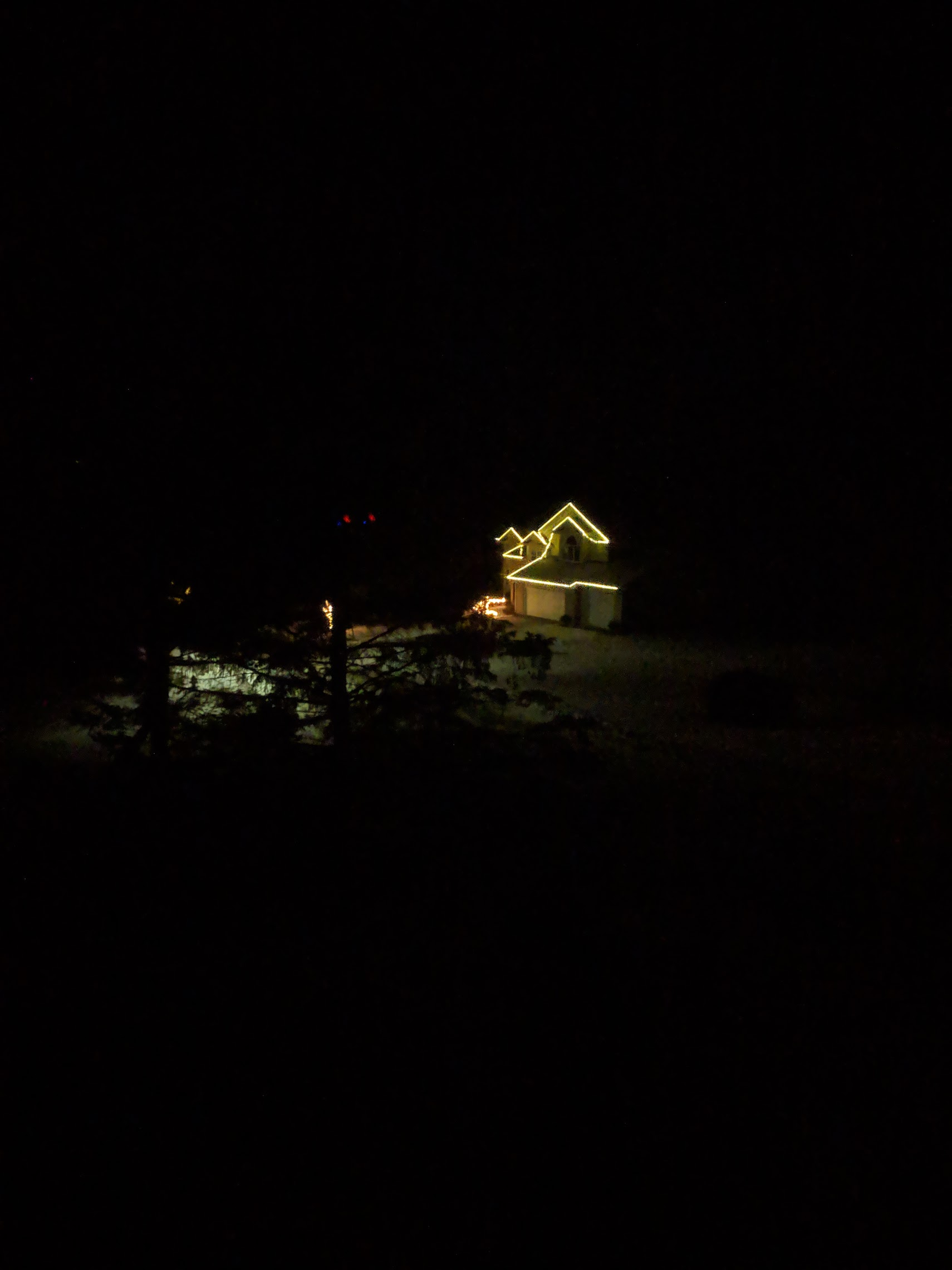 House late at night with christmas lights. Very grainy photo.